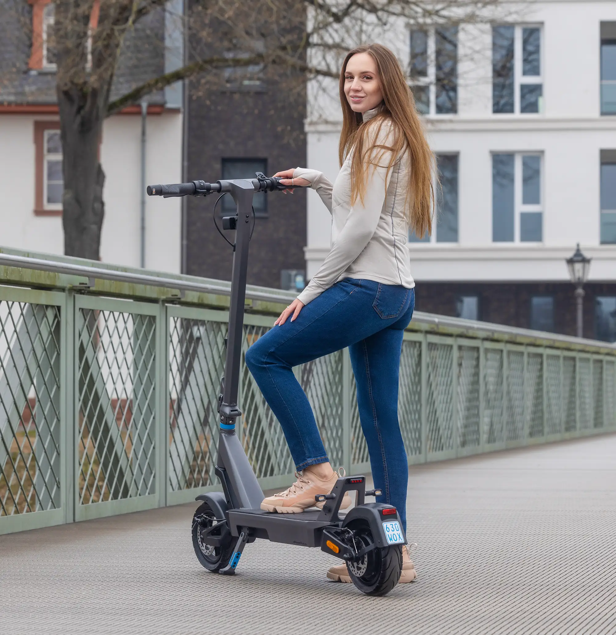 Fahrerin auf dem ePF PULSE + Elektroroller unterwegs auf Brücke – klappbarer E-Scooter mit Straßenzulassung, perfekt für sichere und nachhaltige Mobilität im urbanen Verkehr