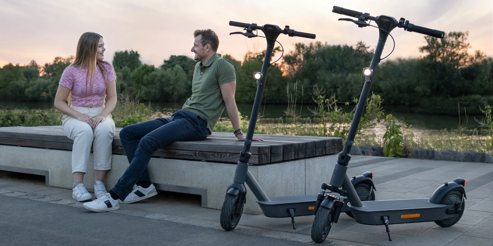eScooter Leihscooter Mobilitaet Zwei nebeneinander abgestellte E-Scooter am Flussufer – gekaufte e-Scooter sind immer verfügbar und ihr Verwendungsgebiet ist nicht reglementiert, was sehr gut zum täglichen Pendelverkehr passt.