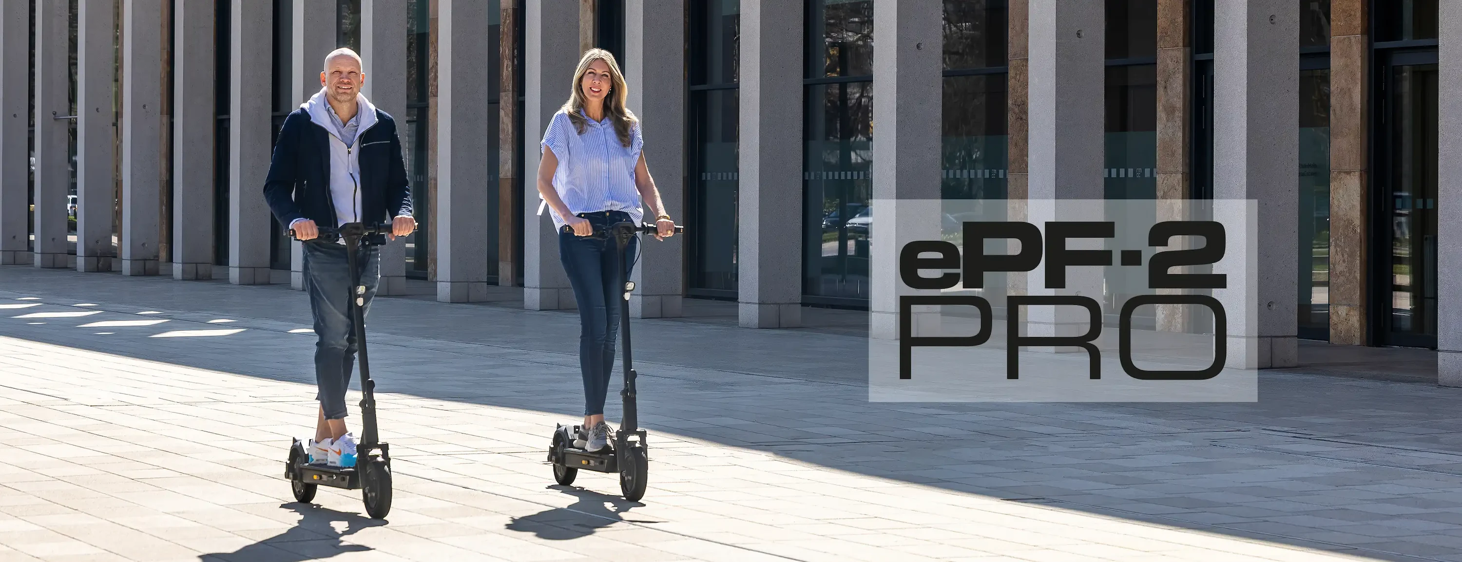 Zwei Personen fahren auf ePF-2 PRO Elektrorollern durch die Stadt – leistungsstarke E-Scooter mit hoher Reichweite, ideal für Pendler und urbane Mobilität mit Stil