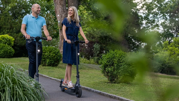 Fahrer auf ePF-2 Elektroroller unterwegs in grüner Gartenanlage – nachhaltige und flexible Mikromobilität mit klappbarem E-Scooter für entspannte Fahrten im urbanen und grünen Umfeld