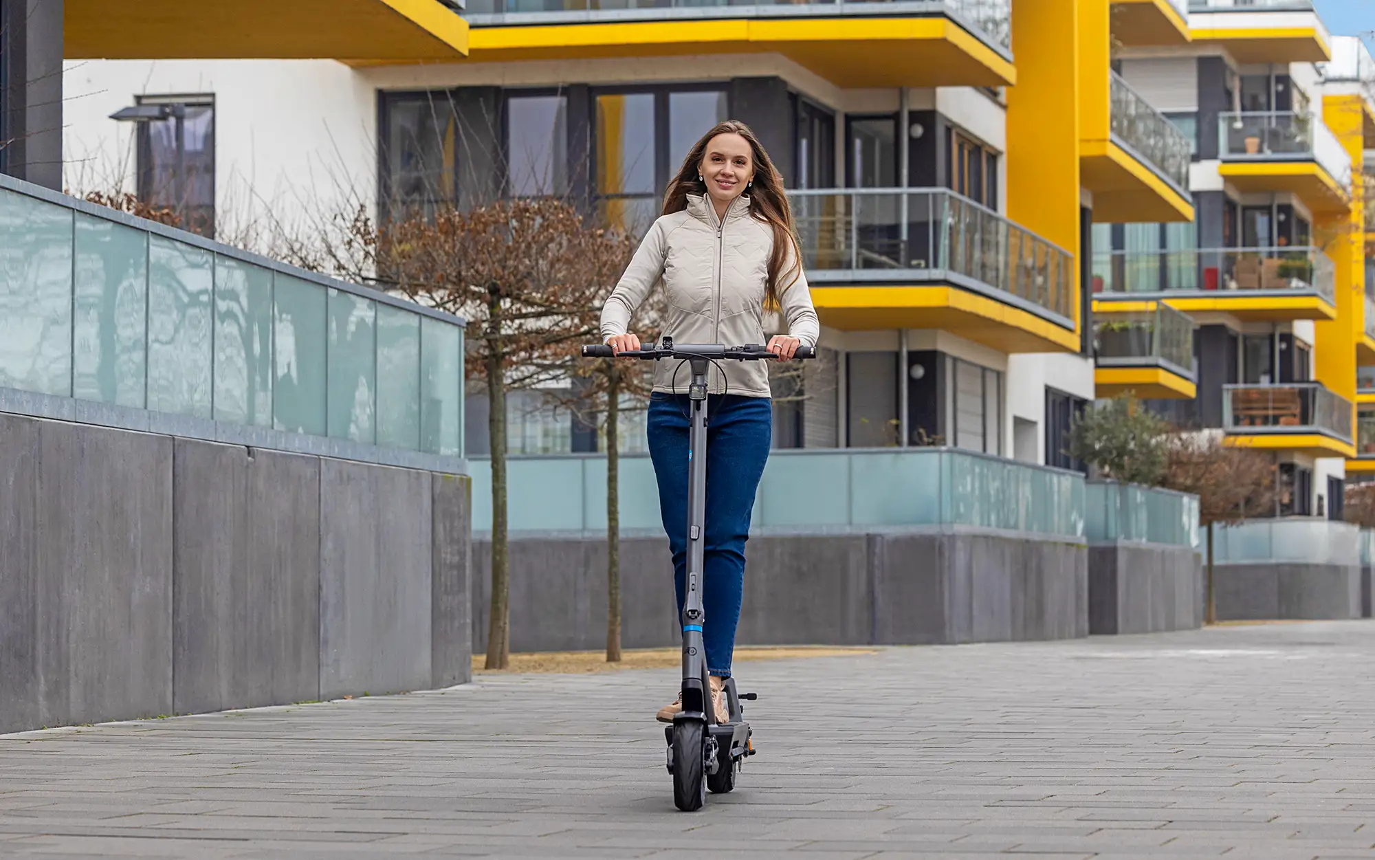 Fahrerin auf dem ePF PULSE + Elektroroller im Wohngebiet – klappbarer E-Scooter mit Straßenzulassung, ideal für sichere und nachhaltige Mobilität im urbanen Alltag