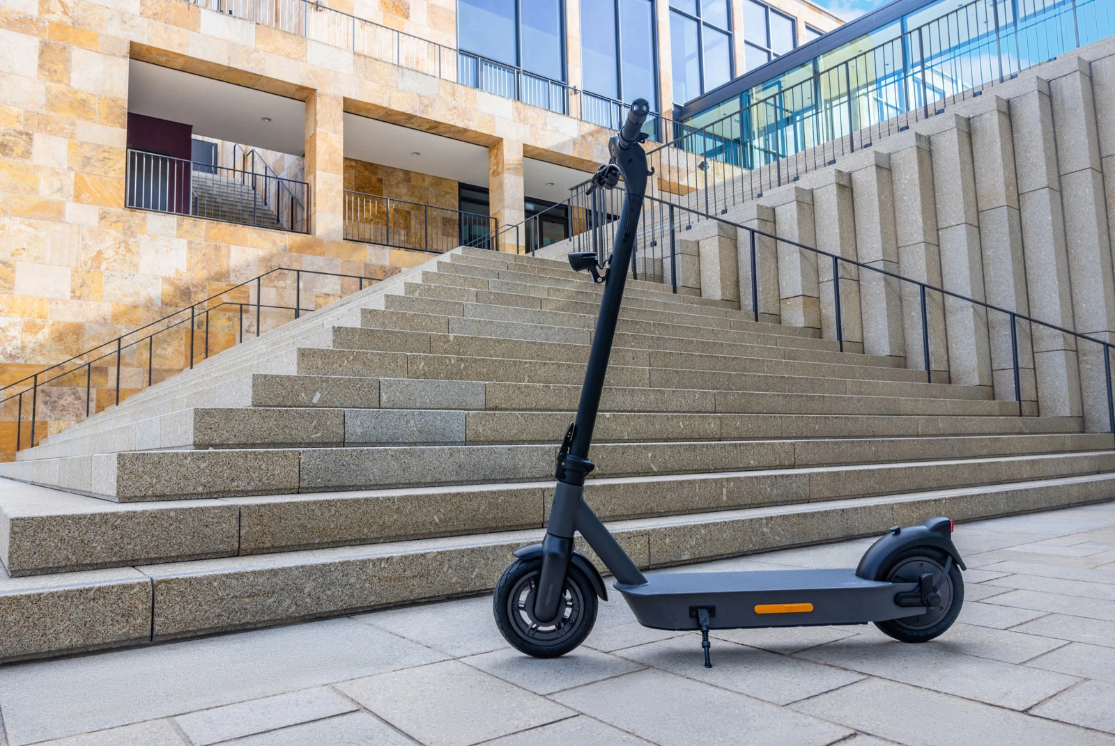 ePF-2_Roller_moderne-Treppen ePF-2 Elektroroller vor modernen Treppen – stilvoller, klappbarer E-Scooter mit Straßenzulassung, ideal für urbane Mobilität und modernes Stadtbild