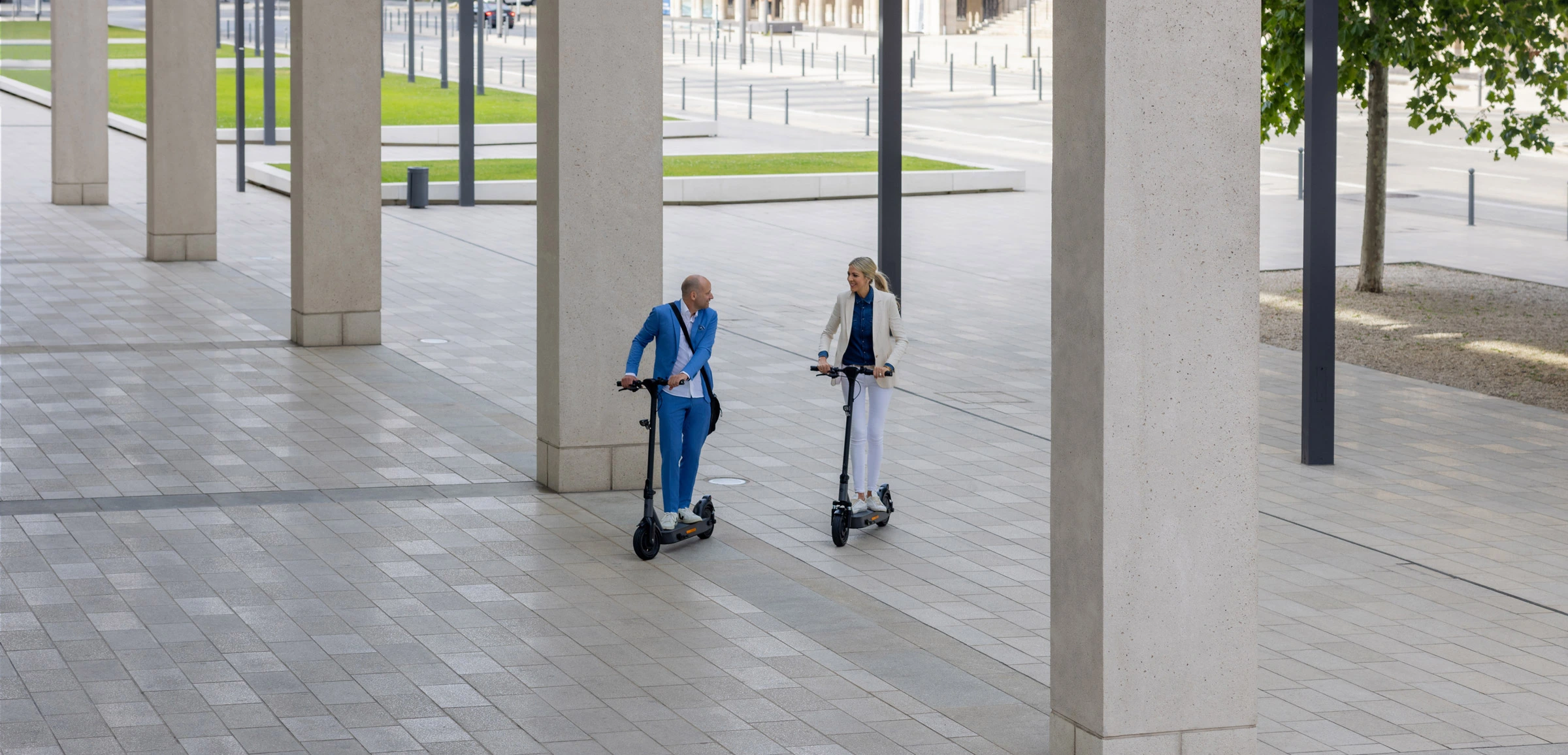 ePF-2 Fahrer bei modernem Betonkomplex – stilvoller Elektroroller mit Straßenzulassung, ideal für urbane Pendler, Mikromobilität und nachhaltige Fortbewegung im Stadtumfeld